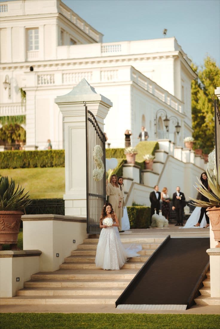 La sposa scende le scale di una villa durante il matrimonio